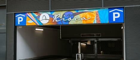 A parking garage entrance with a colorful sign above it.