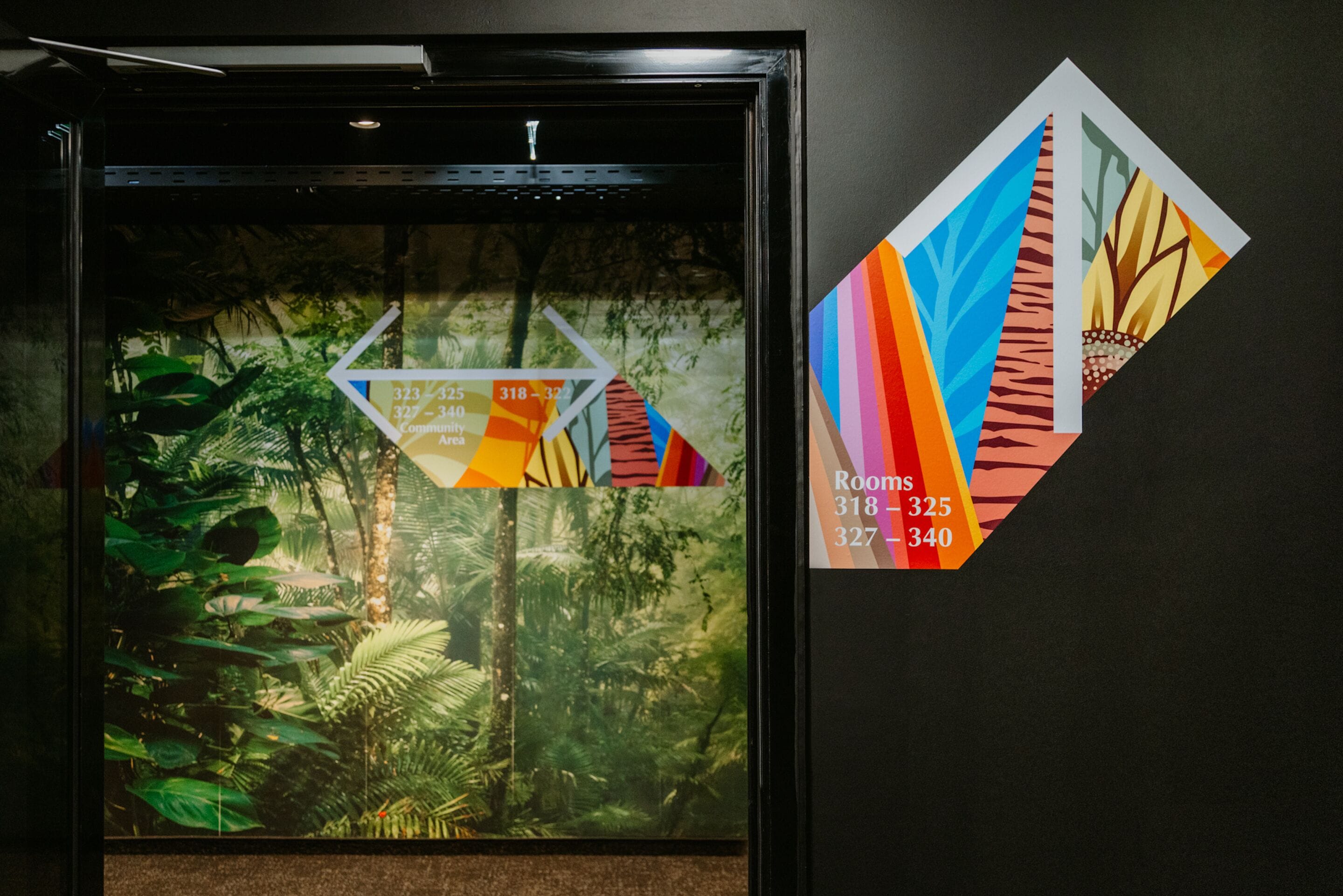 A framed map with room numbers and a tropical wallpaper.