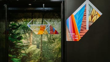 Un mapa enmarcado con números de habitación y un papel tapiz tropical.