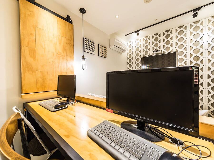 A modern office space with a wooden desk, a computer monitor, keyboard, and a chair.