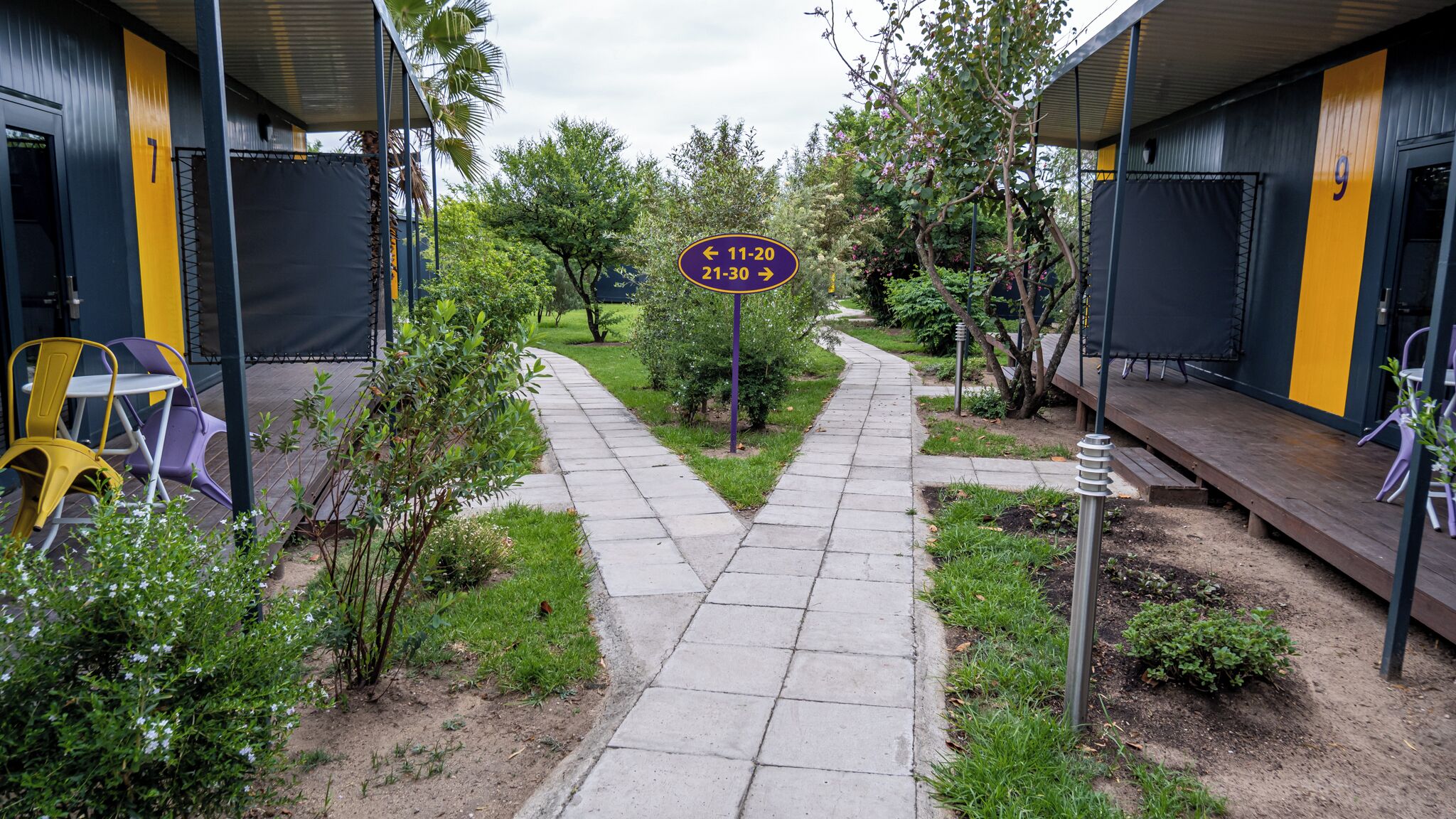 Un sendero conduce a un edificio con un cartel que indica los números de habitación 7 y 9.