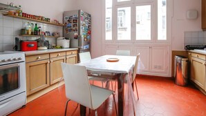 Une cuisine équipée d’une table à manger, de chaises, d’un réfrigérateur et de divers appareils de cuisine.