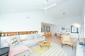 Un salon spacieux comprenant un canapé, une table basse et un coin repas avec des chaises et une table.