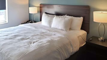 A neatly made bed with white linens, a wooden headboard, and two bedside lamps on nightstands.