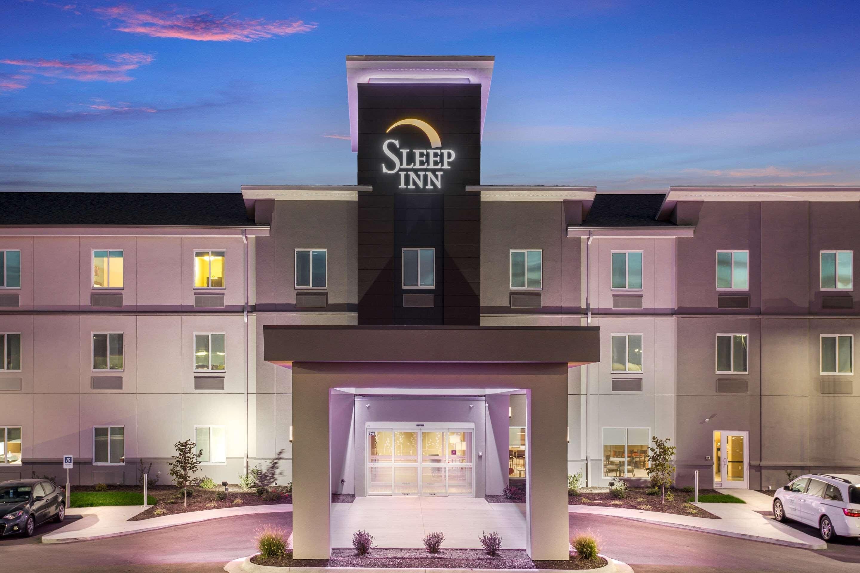 Un hotel Sleep Inn con una facciata moderna, diversi ingressi e un ingresso ben illuminato.
