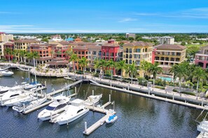 A marina with colorful buildings and boats docked. - Lavish Condo | Courtyard View, Gym, Pool & Spa (Marco Island)