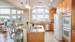 Enjoy cooking in this well-equipped kitchen with a central island, sink, and refrigerator.