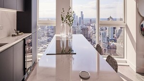 Een moderne keuken met een ruim kookeiland, stadszicht en hanglampen.