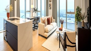 Een moderne woonkamer met een bank, salontafel en uitzicht op de stad.