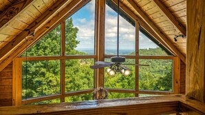 Una habitación con un amplio ventanal que ofrece vistas a un paisaje boscoso.