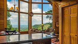 Una cocina amplia con una isla grande, armarios de madera y vistas al exterior.