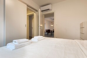 Ein Hotelzimmer mit Bett, Bad und einem Essbereich, der durch eine offene Tür sichtbar ist.