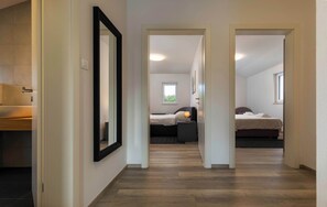 A hallway leading to a bedroom with a bed, bedside table, and a window. - Villa Aurora (Sveti Lovrec Labinski)