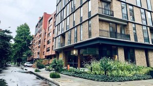 A multi-story building with a modern architectural design, featuring a mix of brick and glass facades. - w*| Modern Duplex in Parque Virrey (Bogotá)