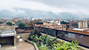 A rooftop terrace with a view of a cityscape and mountains. - w*| Modern Duplex in Parque Virrey (Bogotá)