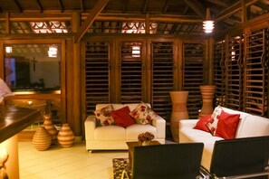 A cozy living area with a white sofa, red cushions, and decorative vases. - Hotel Tetiaroa (Maraú)
