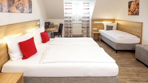 Une chambre d’hôtel avec deux lits, une petite table et une chaise.