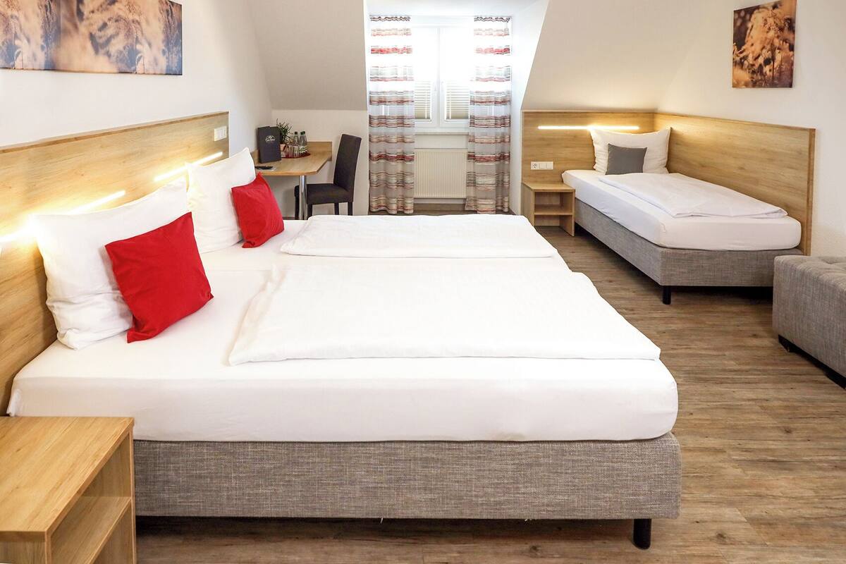 Ett hotellrum med två sängar, ett litet bord och en stol.