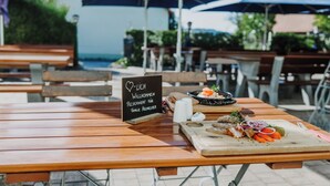 Une table de jardin en bois, avec une pancarte indiquant qu’elle est réservée au nom de la famille Hochreuter.
