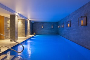 Una piscina techada, sillones reclinables de piscina