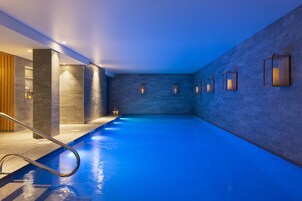 Una piscina techada, sillones reclinables de piscina