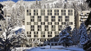Un immeuble à plusieurs étages doté d’une façade symétrique, de grandes fenêtres et d’un toit plat.
