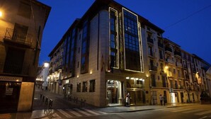 Un hotel con fachada moderna, amplias ventanas y entrada a nivel de la calle.
