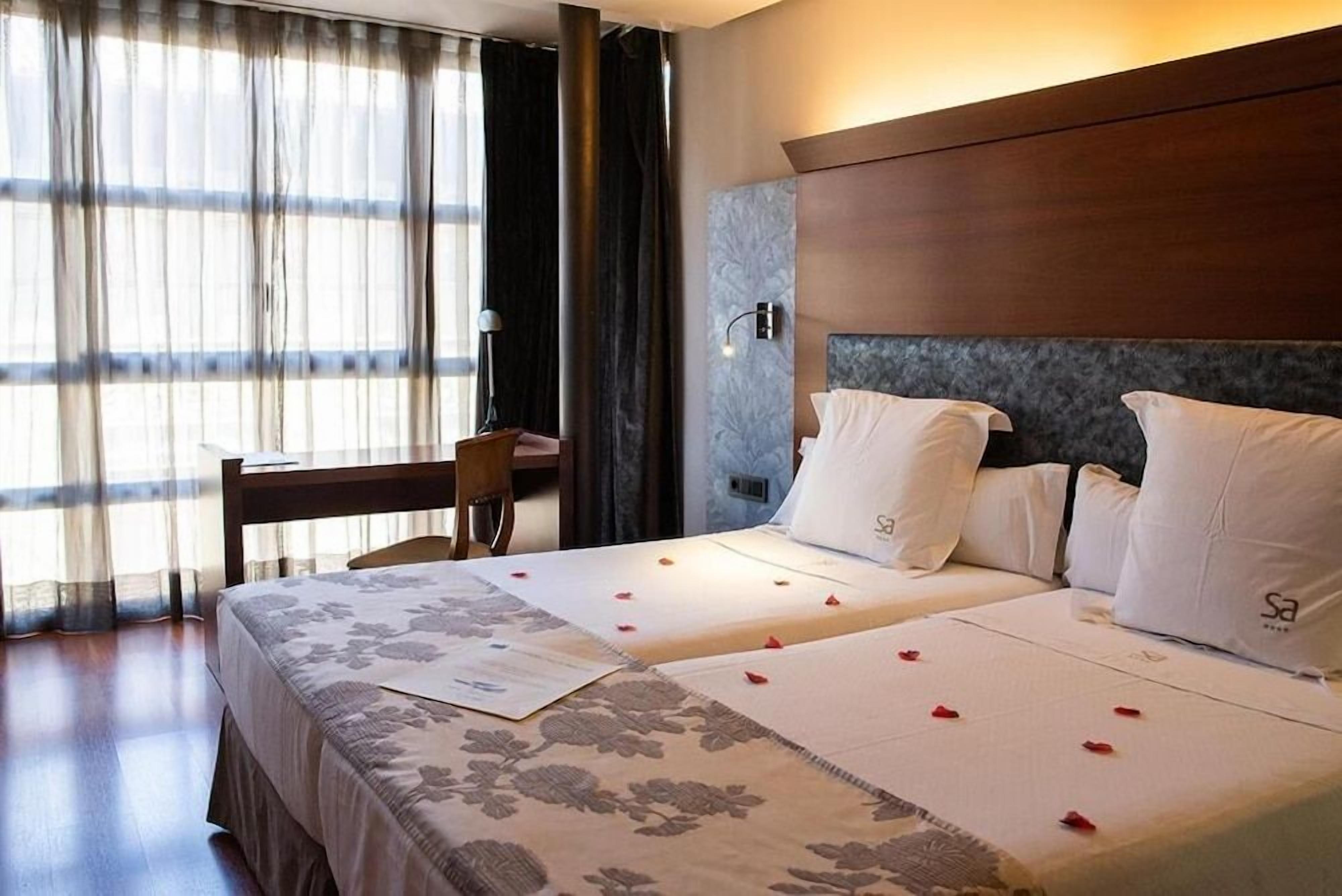 Una habitación de hotel con una cama, un escritorio y una silla.