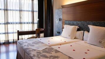 Una habitación de hotel con una cama, un escritorio y una silla.
