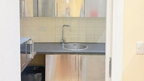 A compact kitchen with a sink, cabinets, and a countertop. - Europa House (London)