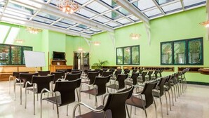 A conference room with rows of chairs, a whiteboard, and a television. - Hotel Julia (Madrid)