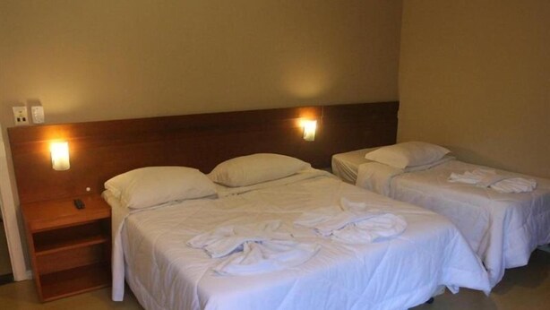 A hotel room with two beds, each with a wooden headboard and bedside lamps. - Laponia Hotel Gramado (Gramado)