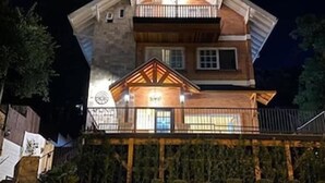 A two-story building with a balcony on the upper level, a brick facade, and a well-lit entrance. - Laponia Hotel Gramado (Gramado)