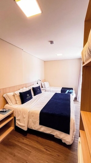 A hotel room with two beds, a bedside table, a lamp, and a ceiling light. - Laponia Hotel Gramado (Gramado)