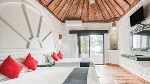 A hotel room with two beds, a large window, a wooden ceiling, and a TV mounted on the wall. - Hotel Mimi Del Mar (Playa del Carmen)