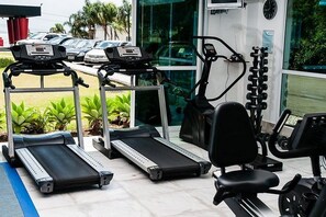 A gym with treadmills, an elliptical, and a weight bench. - Encantos Golden Hotel (Sao Jose)