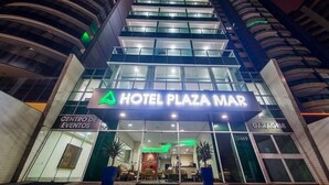 Un hotel de varios pisos con un llamativo letrero que dice "Hotel Plaza Mar".