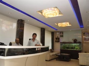 Welcome to our reception area, featuring a sleek reception desk, comfortable seating, and a beautiful fish tank.