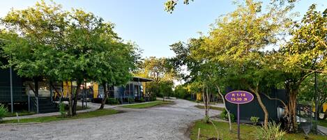 A gravel driveway leading to a building with a sign indicating parking availability.