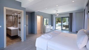 A modern hotel room with a large bed, a bathroom with a shower, and a balcony with a view. - Five Stars Villa Corfu (Corfu)