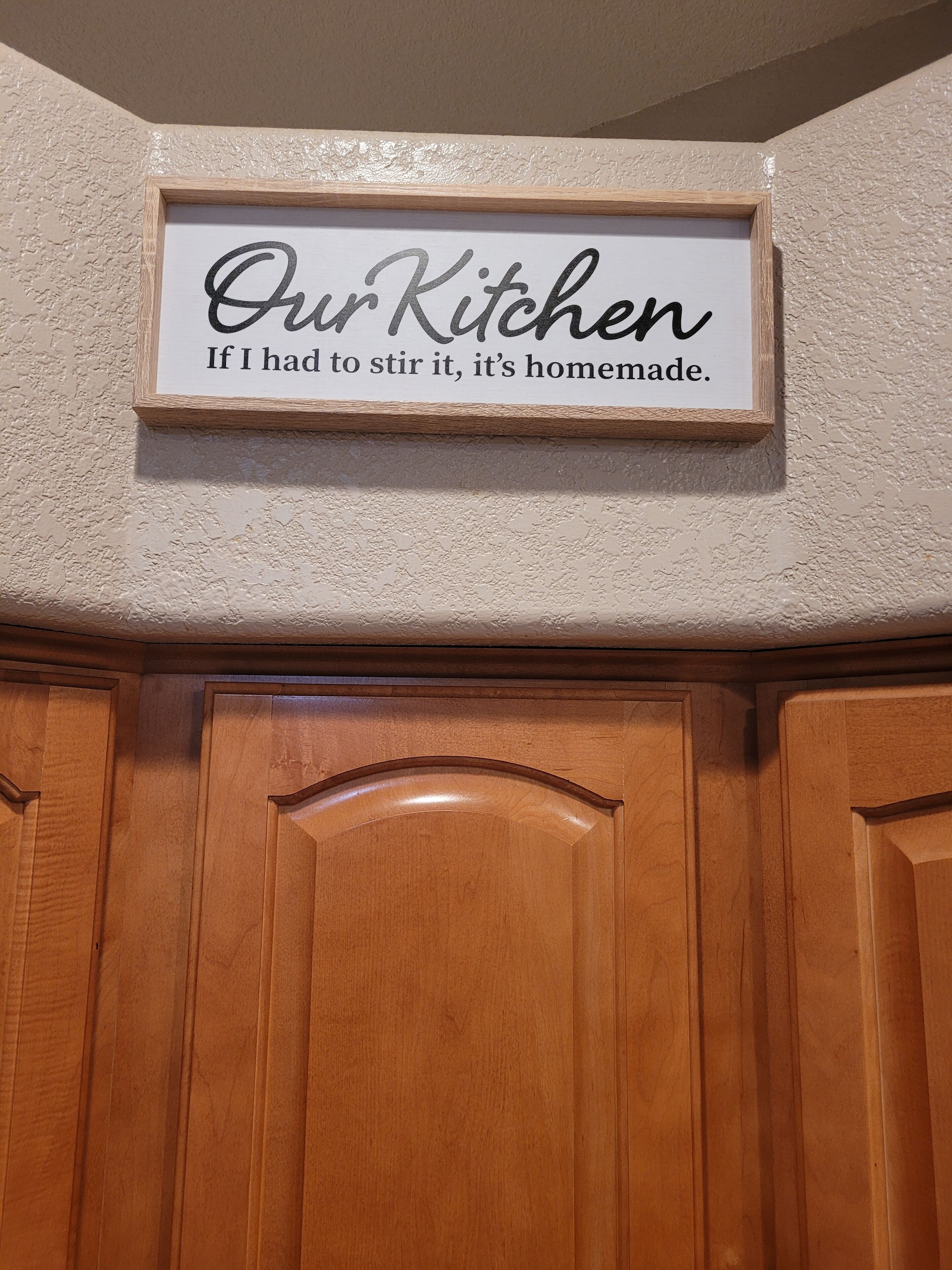 Une pancarte dans la cuisine avec l’inscription : « Notre cuisine : si je dois remuer, c’est que c’est fait maison. »