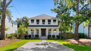 A two-story house with a front porch, a central door, and a symmetrical window arrangement.