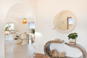 A modern interior with a dining area, a large mirror, and a unique seating arrangement. - TerraCasa-Hot Tub, Fire Pit,Outdoor Shower &Views! (Yucca Valley)