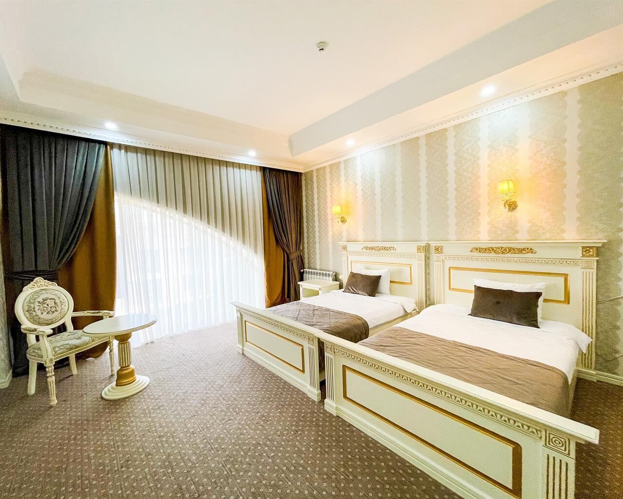 Une chambre d’hôtel avec deux lits, une petite table et une chaise.