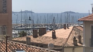 Un pueblo costero con tejados de tejas color terracota y un puerto deportivo lleno de veleros.