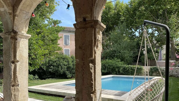 A poolside area with a hanging chair, a table, and a lamp. - Town house with swimming pool and private garden (Pélissanne)