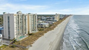 A coastal hotel with multiple high-rise buildings, a beach, and a clear sky. - Ocean Bay Club 202-4BR/3BA Oceanfront-Ocean Drive (North Myrtle Beach)