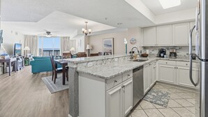 A modern kitchen with white cabinets, a granite countertop, and stainless steel appliances. - Ocean Bay Club 202-4BR/3BA Oceanfront-Ocean Drive (North Myrtle Beach)