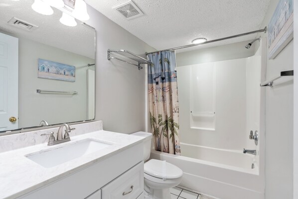 A bathroom with a white sink, toilet, and bathtub. - Ocean Bay Club 305-4BR/3BA Oceanfront condo in Ocean Drive (North Myrtle Beach)