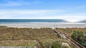 A beach with a wooden boardwalk leading to the shore, sandy beach, and ocean. - Ocean Bay Club 503-4BR/3BA Oceanfront condo in Ocean Drive (North Myrtle Beach)